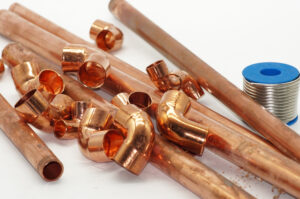 Closeup shot of copper metal pieces for construction on a white surface